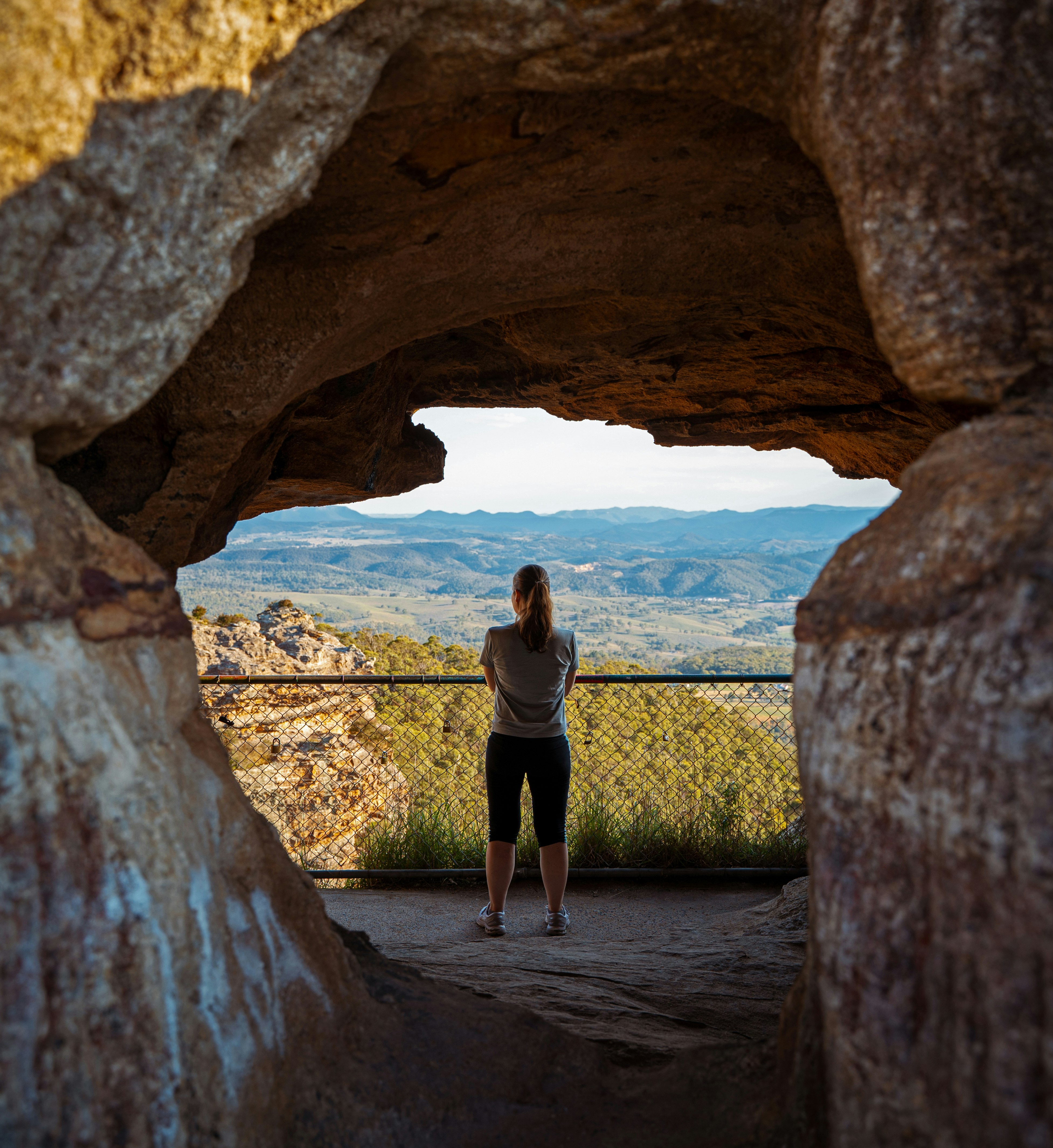 woman in black dress standing on rock formation during daytime